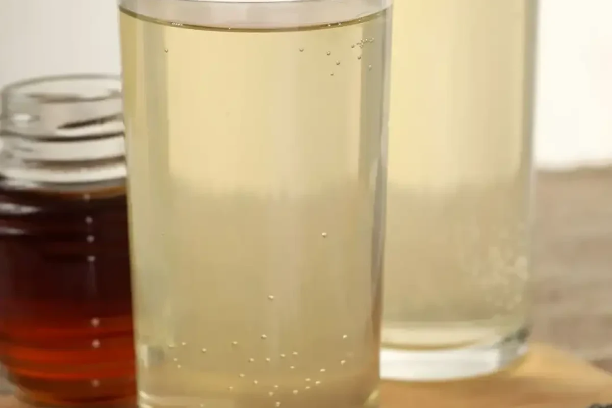 Apple cider vinegar and baking soda with cleaning supplies on a kitchen counter