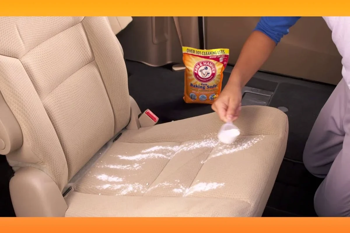 Baking soda sprinkled on car carpet to remove odor inside a clean vehicle