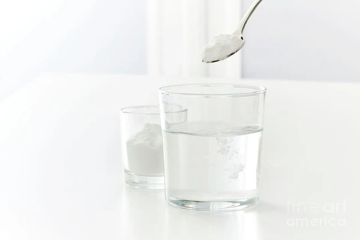 Baking soda dissolving in a glass of water on a kitchen counter