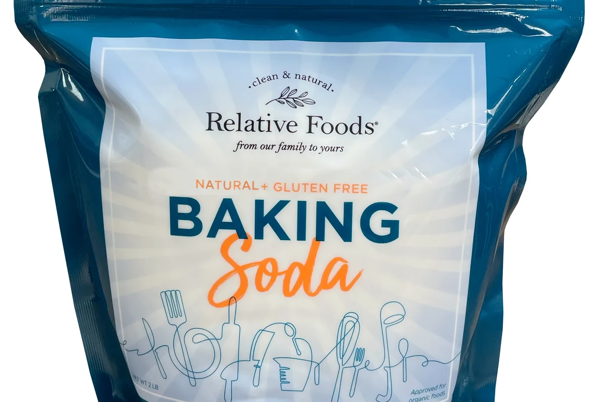 Baking soda container beside gluten-free flour and measuring spoons in a baking kitchen