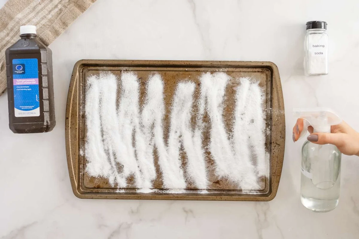 Baking soda paste being applied gently to a scratched stainless steel surface