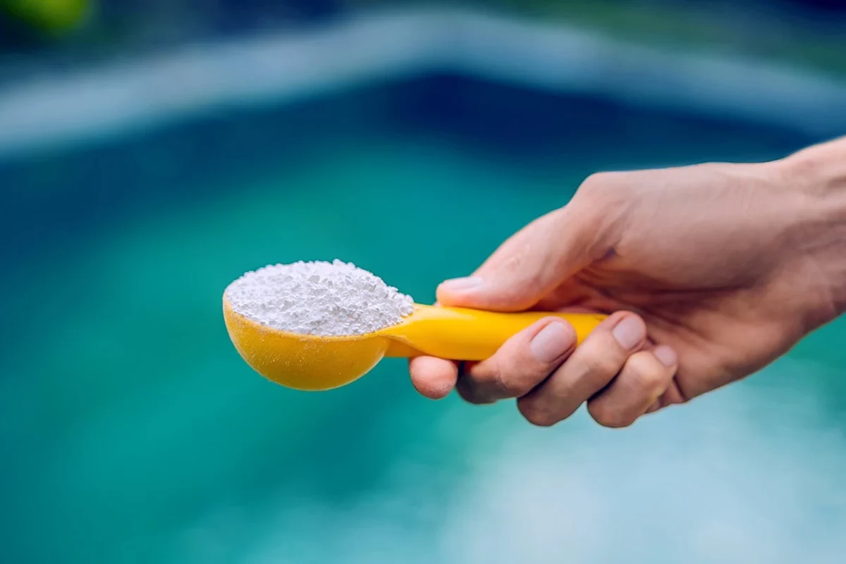 Baking soda being added to pool water to adjust alkalinity