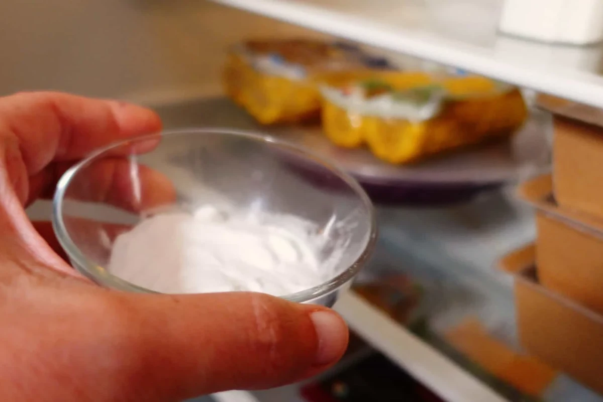 Open box of baking soda in a clean refrigerator shelf for odor control
