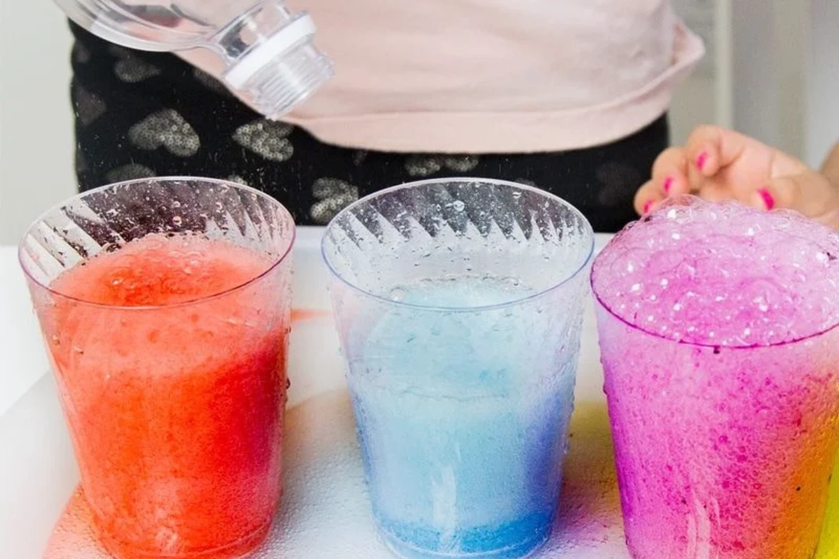 Child-friendly baking soda and vinegar science experiment with foam rising in a clear container
