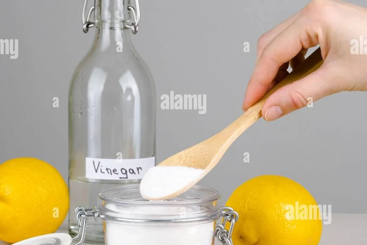 Baking soda and vinegar cleaning a kitchen stain on fabric and cookware