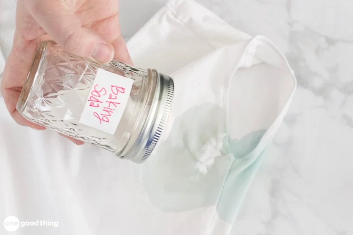 Person removing white baking soda deodorant stains from a dark shirt with gentle laundry treatment