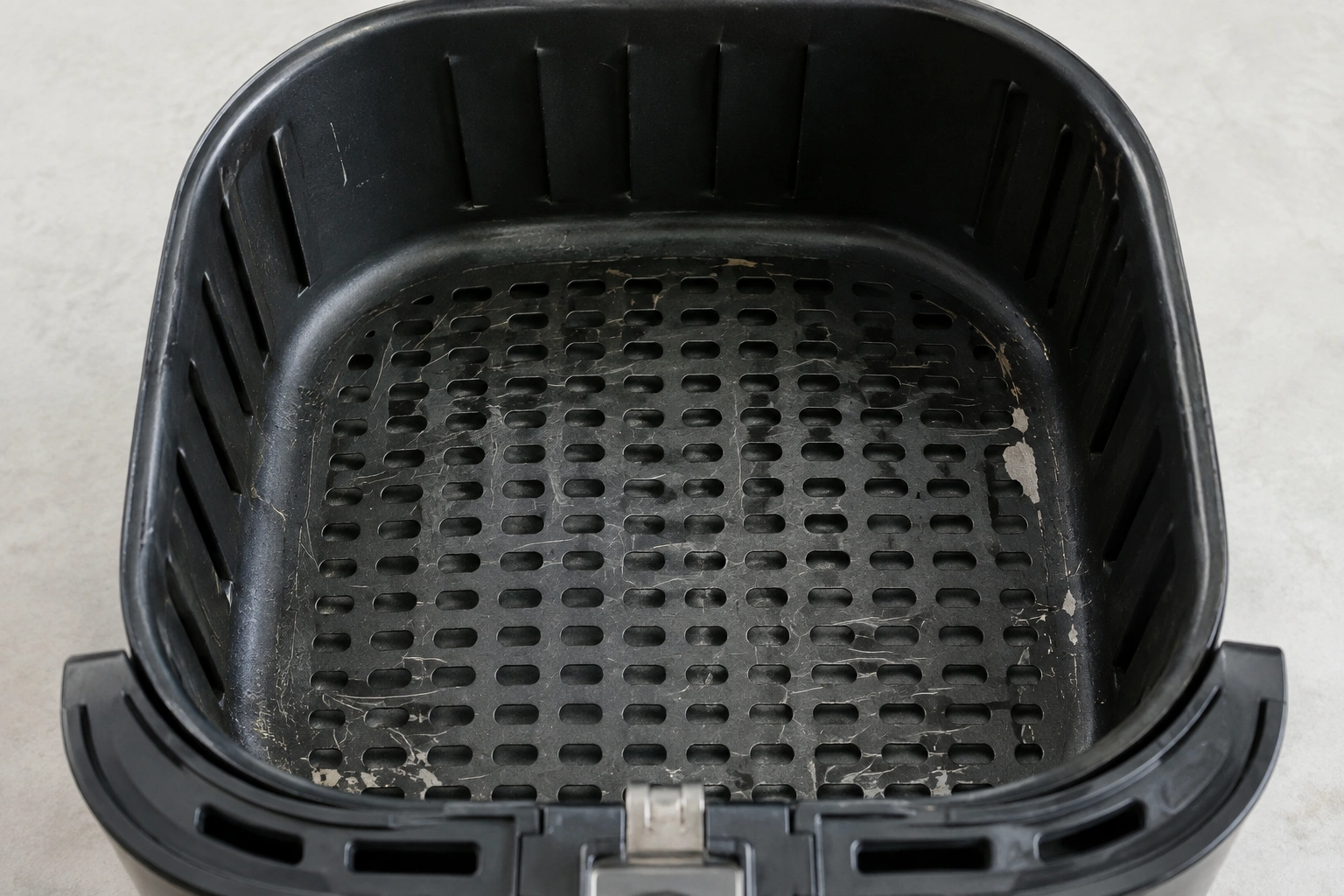 Air fryer basket with visible coating wear