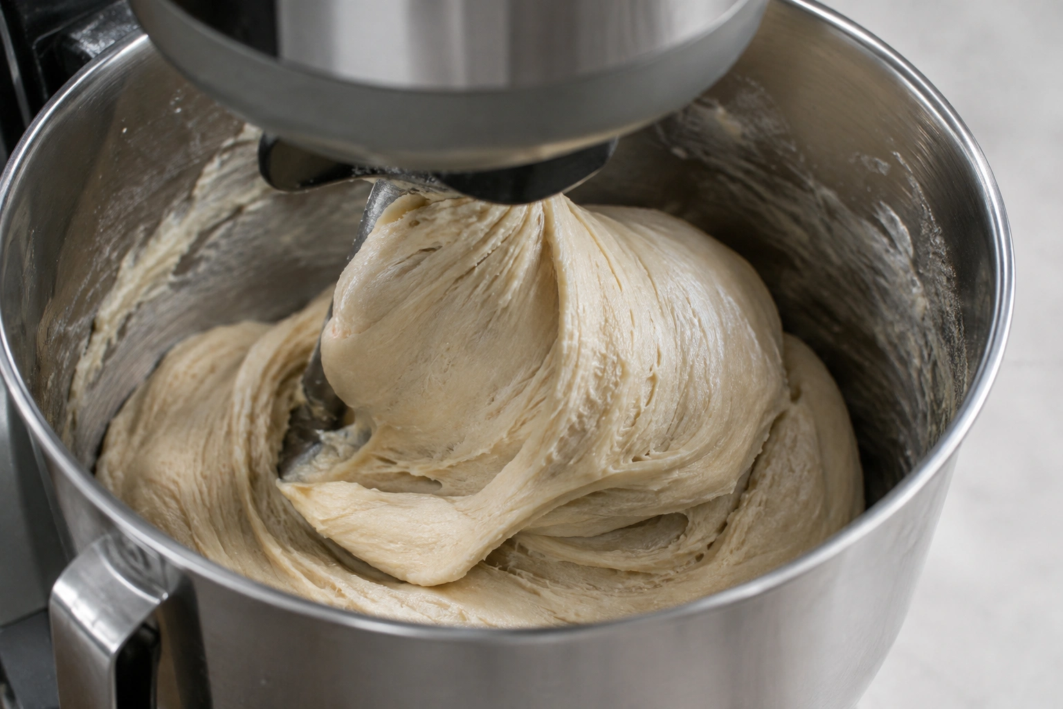 Close-up of bread dough stretching in a mixer bowl