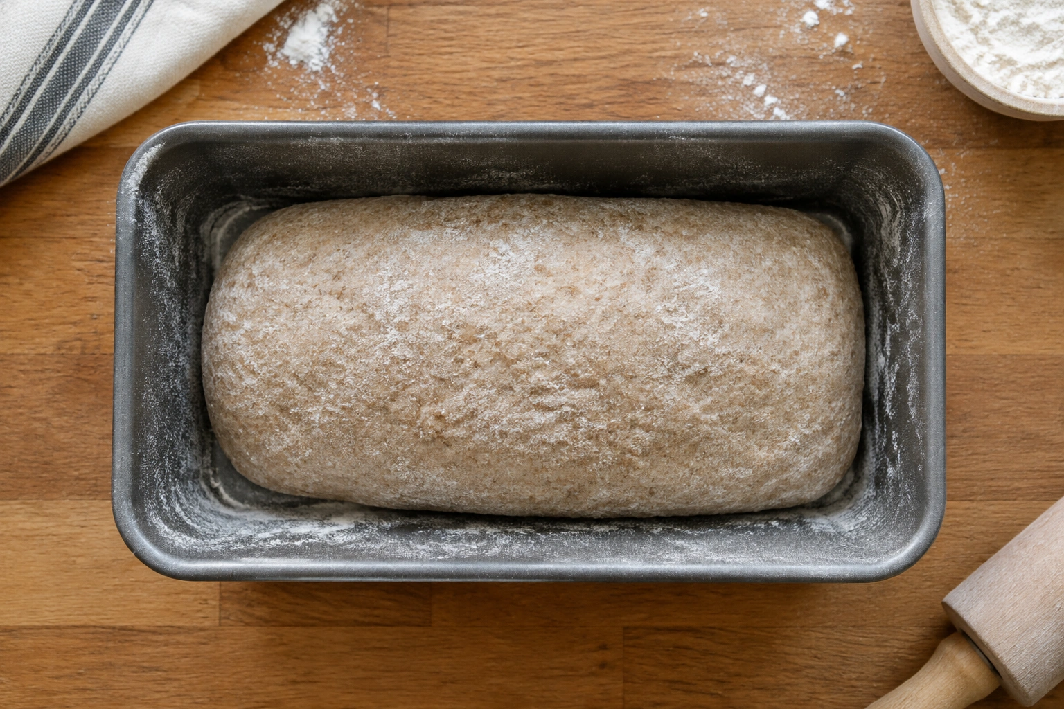 Loaf pan with shaped whole wheat dough ready to proof